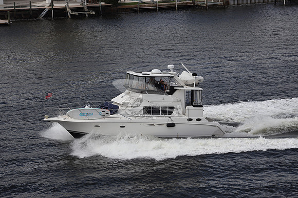 BOAT.WHITE HULL.SURFSTAR SURFBOARD IN FRONT.12